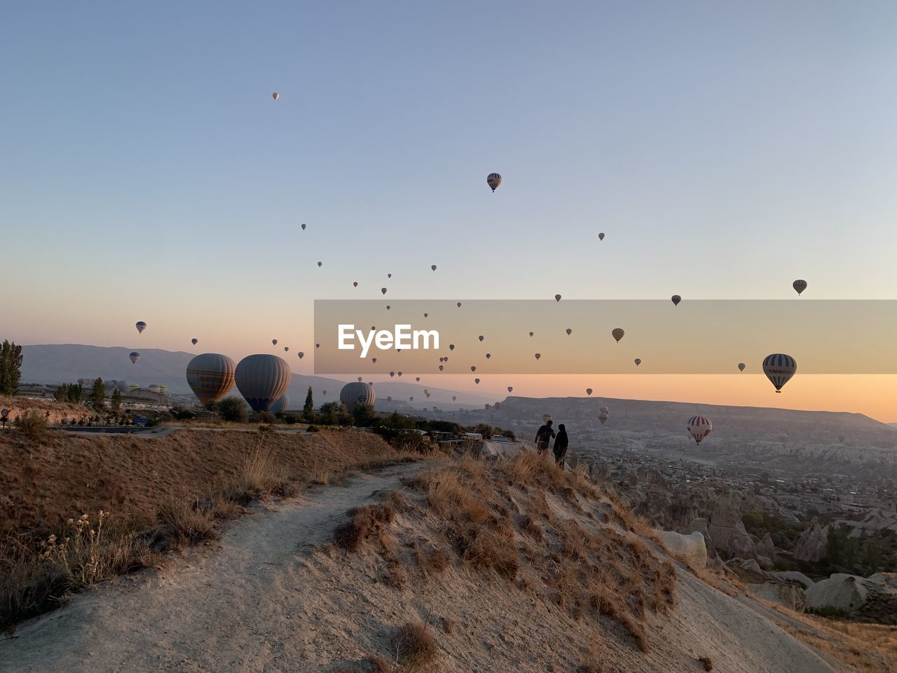 VIEW OF HOT AIR BALLOONS FLYING OVER LAND
