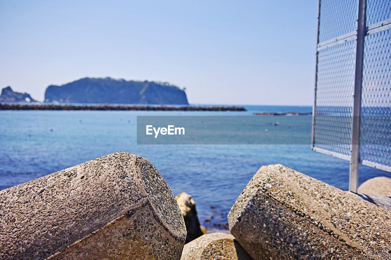 Close-up of rocks on beach against sky