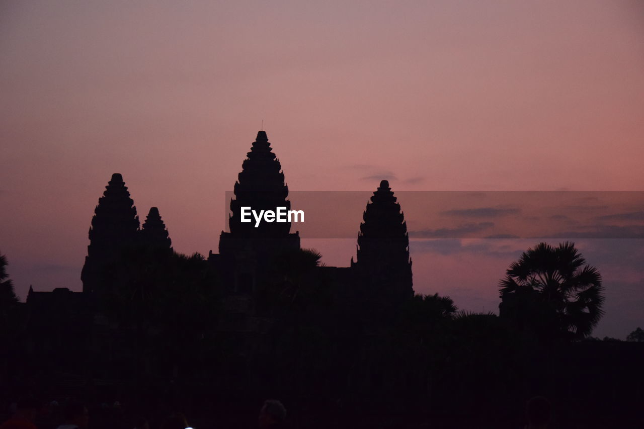 SILHOUETTE OF TEMPLE AGAINST BUILDING