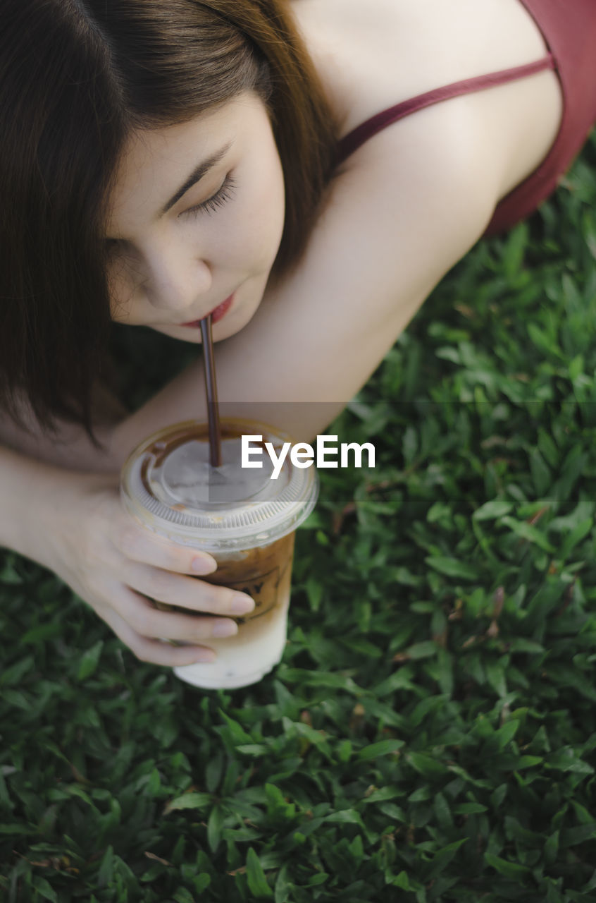 Woman drinking coffee on field