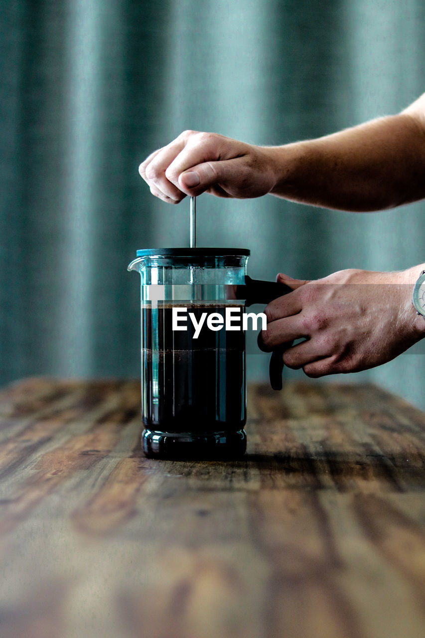 Cropped image of man making coffee on table