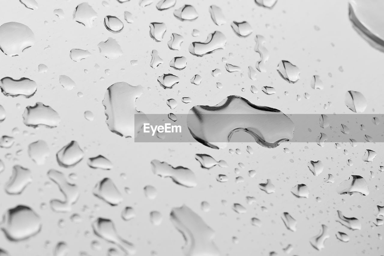 FULL FRAME SHOT OF WATER DROPS ON GLASS