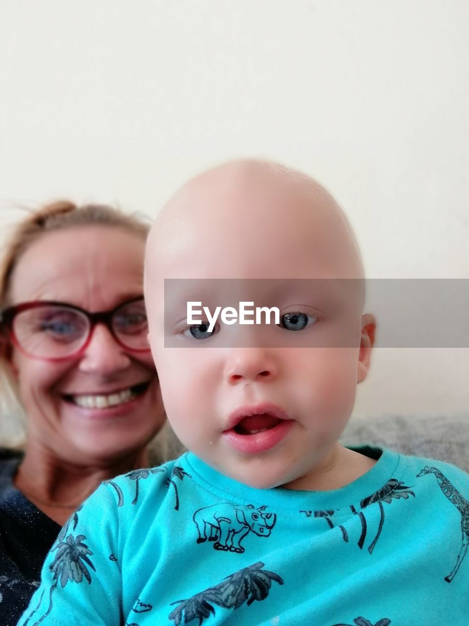 Portrait of cute baby boy with grandmother at home