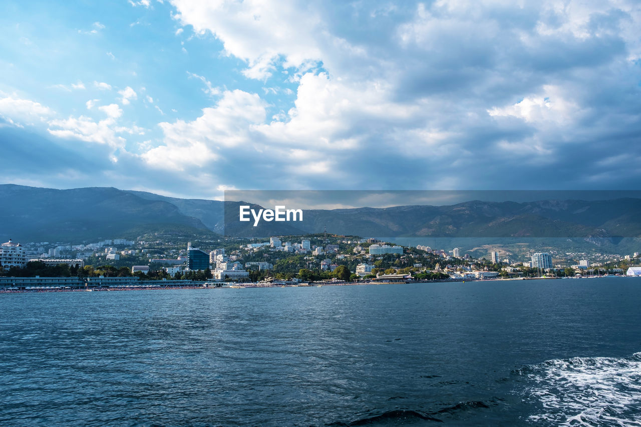 Scenic view of sea by city against sky