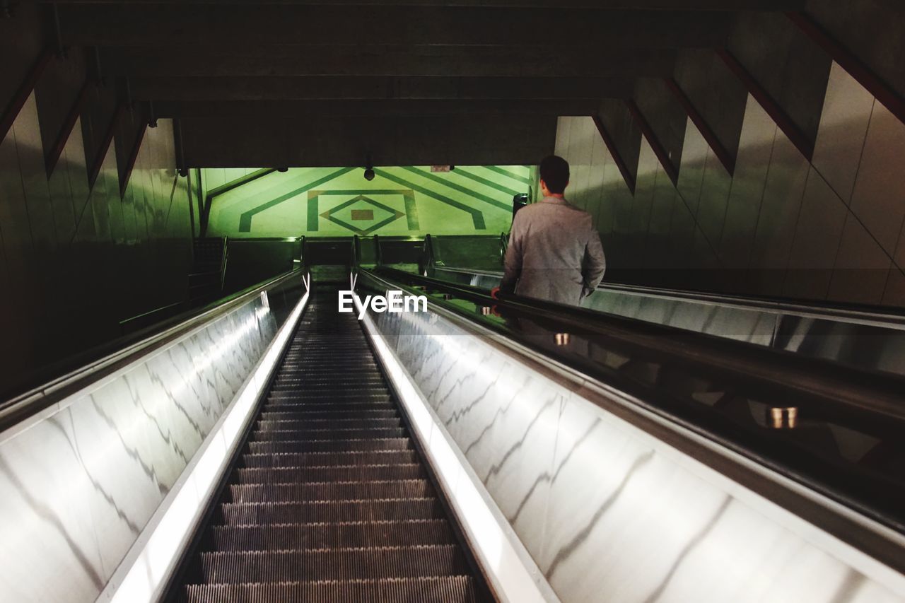 Rear view of businessman escalator in building