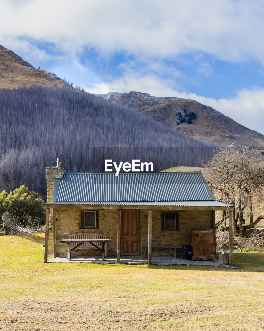 BUILT STRUCTURE ON FIELD AGAINST MOUNTAIN