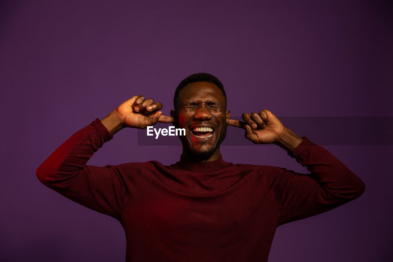 Portrait of smiling young man against gray background