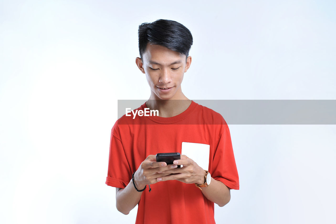 Potrait of young asian student playing a smartphone