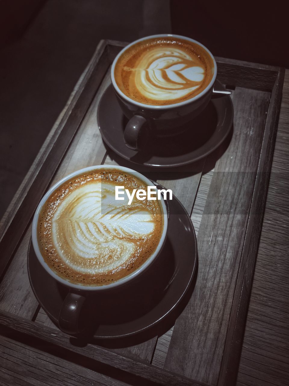 HIGH ANGLE VIEW OF CAPPUCCINO SERVED ON TABLE