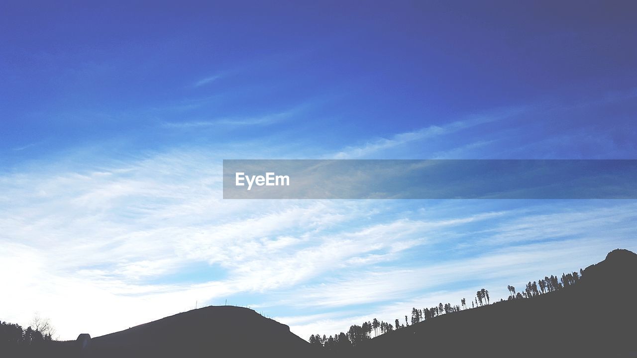 LOW ANGLE VIEW OF SILHOUETTE MOUNTAINS AGAINST SKY