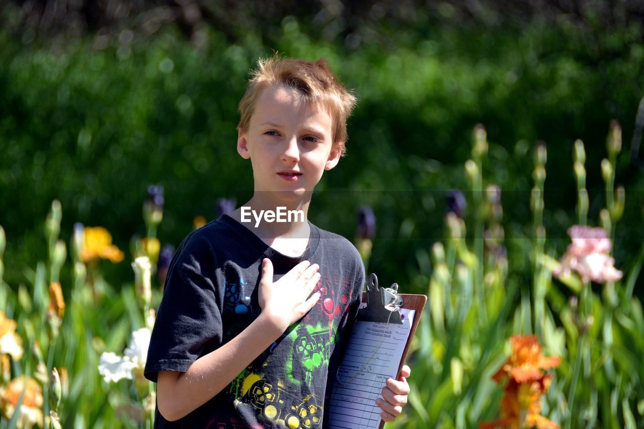 Close-up of boy holding clipboard at park