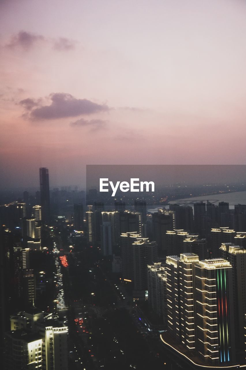 HIGH ANGLE VIEW OF MODERN BUILDINGS AGAINST SKY DURING SUNSET