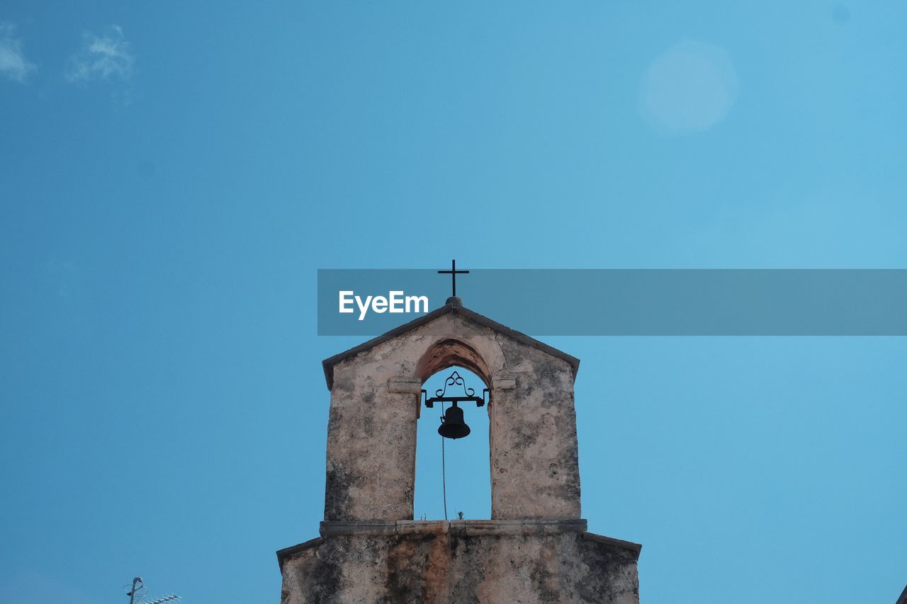 Low angle view of rustic church against clear blue sky