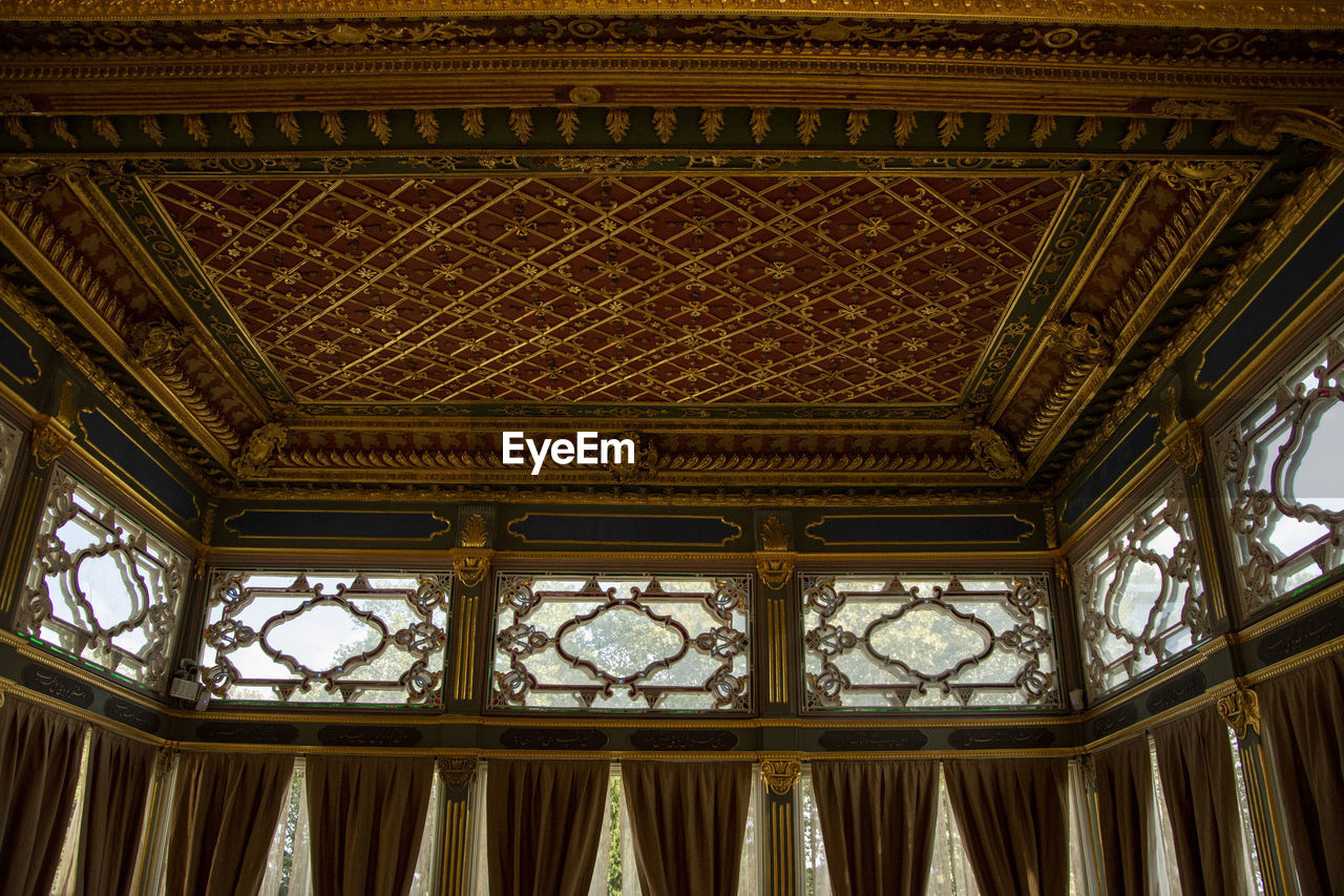 LOW ANGLE VIEW OF ORNATE CEILING OF BUILDING