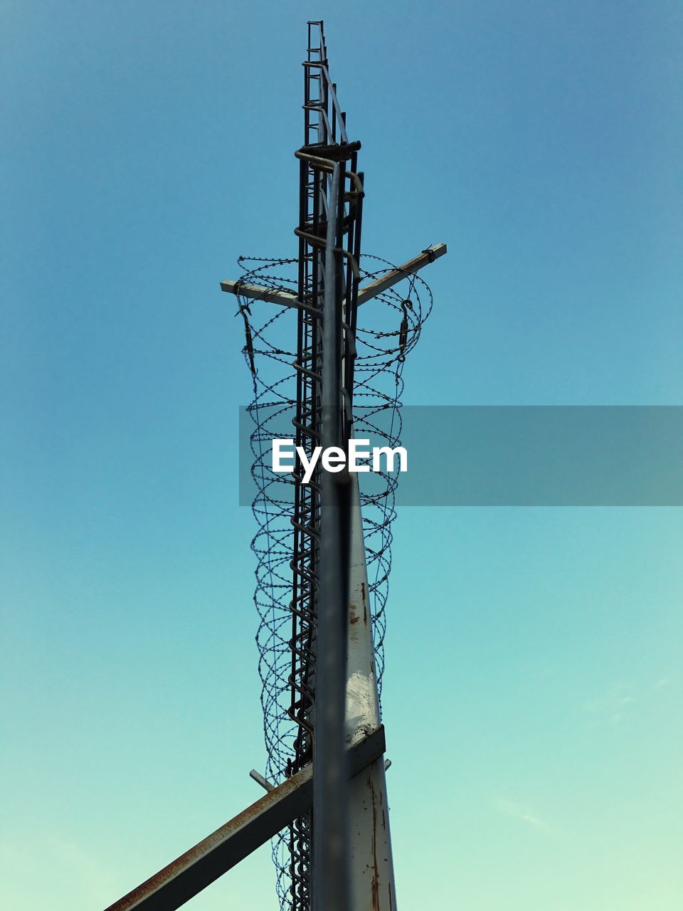 LOW ANGLE VIEW OF CRANE AGAINST CLEAR BLUE SKY