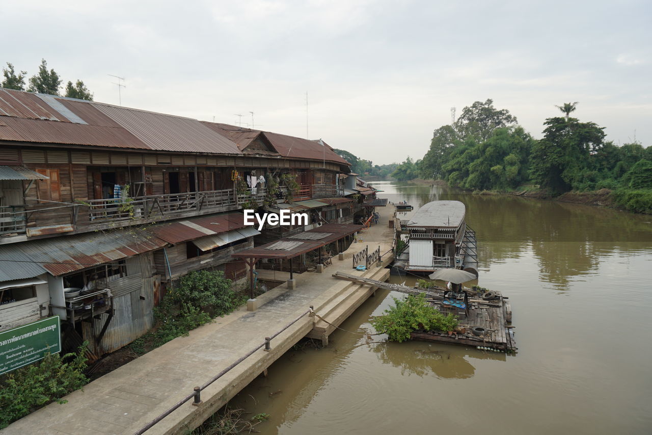 RIVER AMIDST BUILDINGS AGAINST SKY