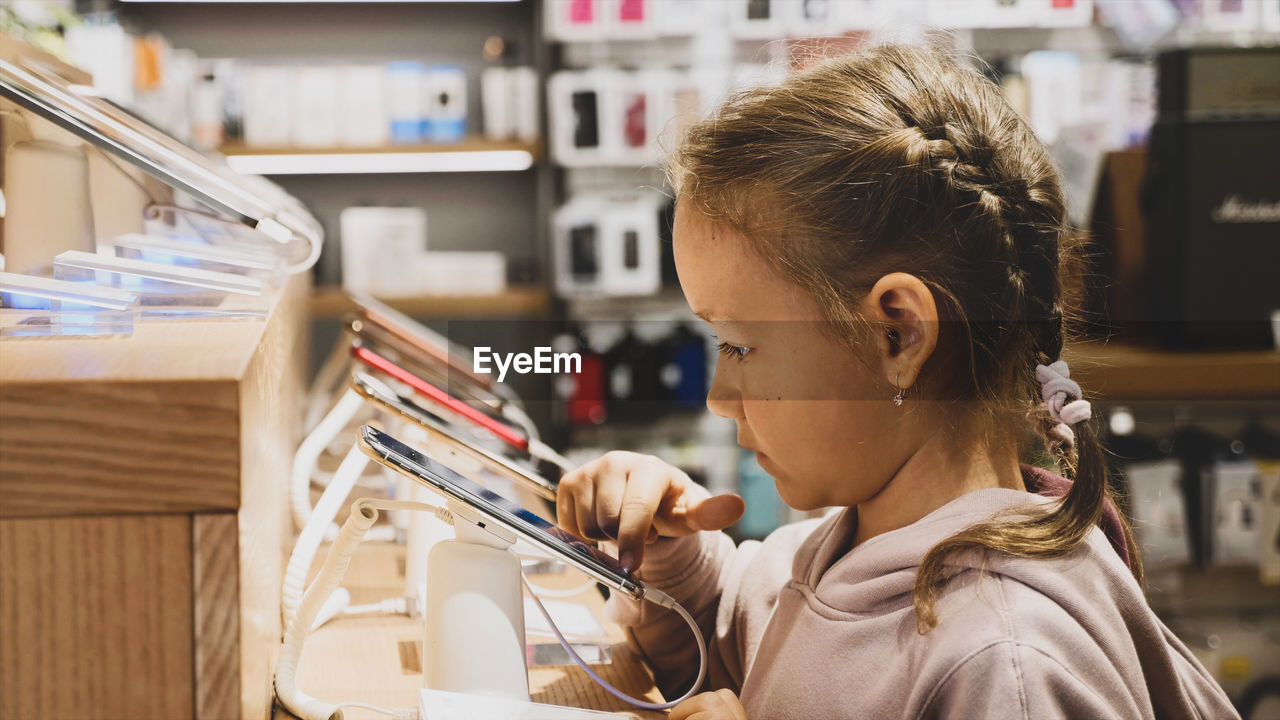 Close-up of girl using smart phone in store