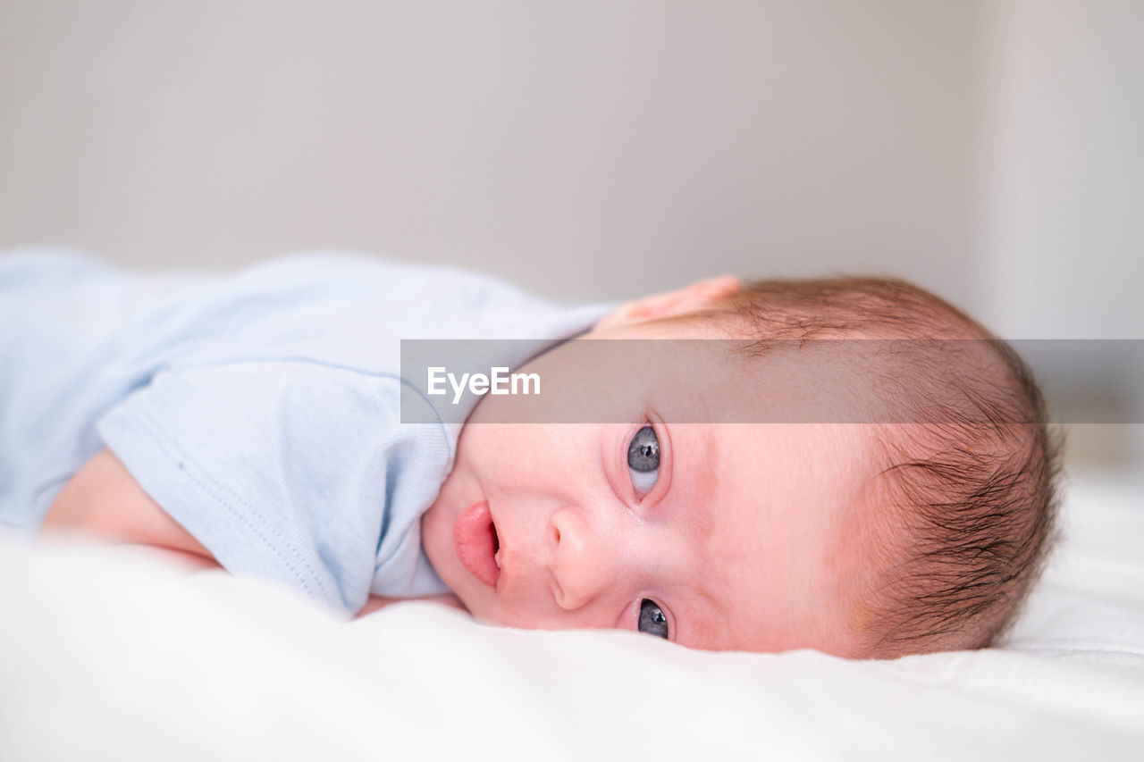 close-up of cute baby girl sleeping on bed at home