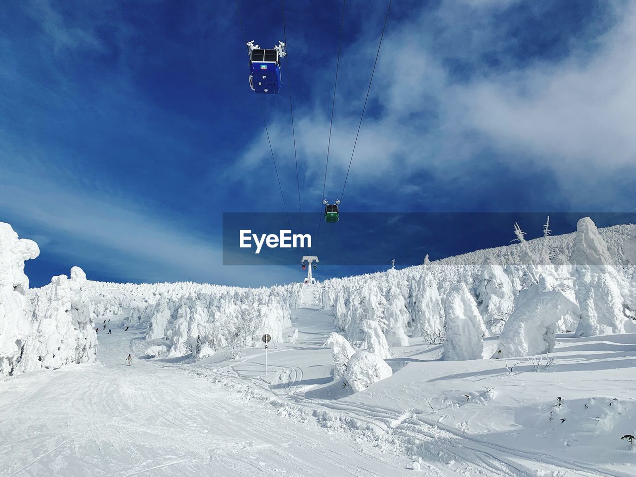 Low angle view of overhead cable cars against sky during winter