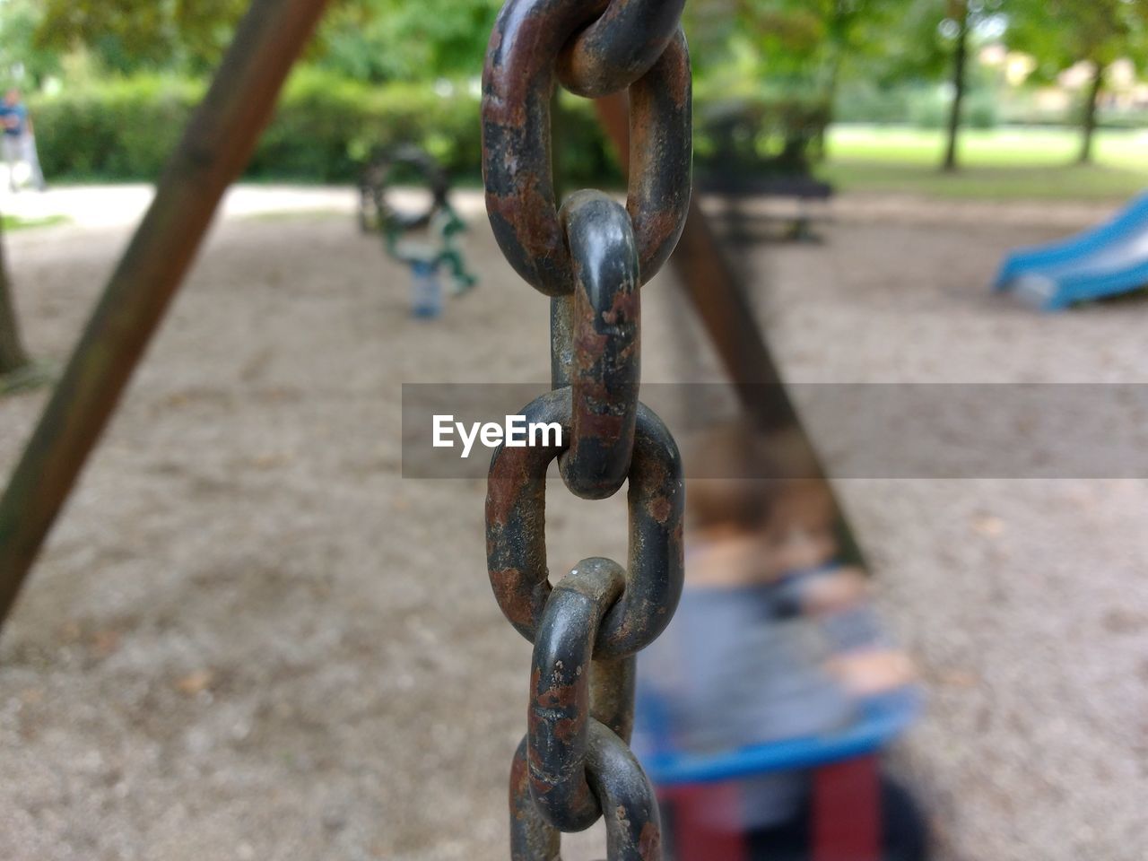 CLOSE-UP OF METAL CHAIN ON PLAYGROUND
