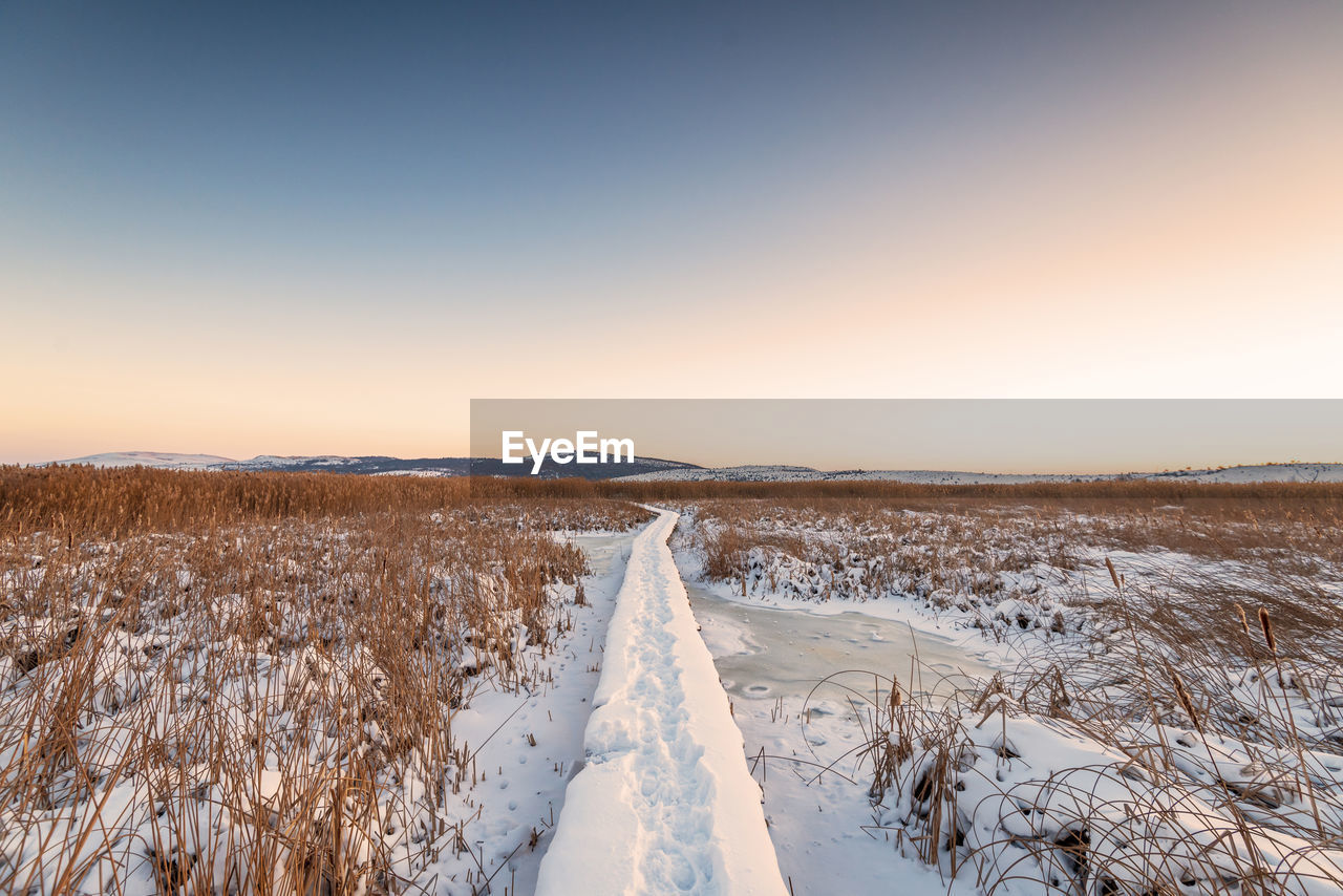 Rural winter landscape. sunrise over snowy road.