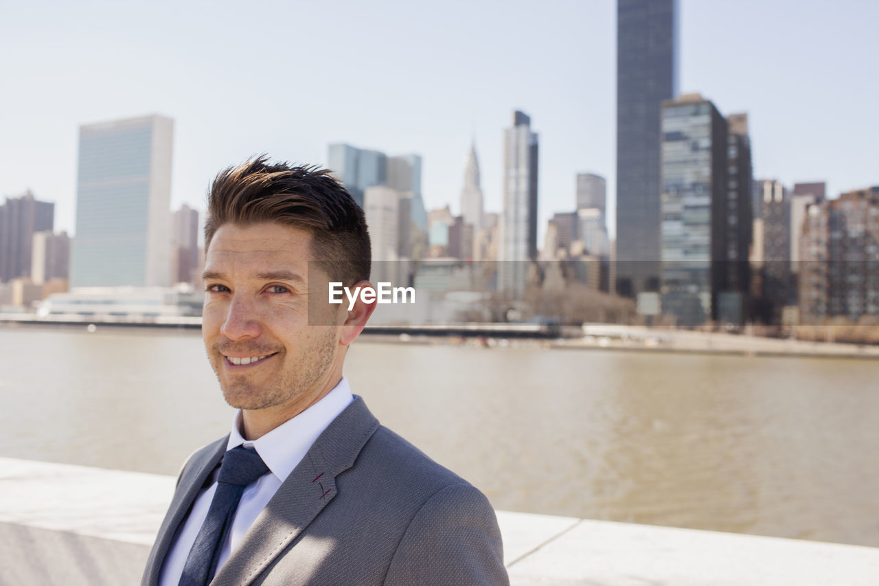 Portrait of a young businessman on a rooftop overlooking the city