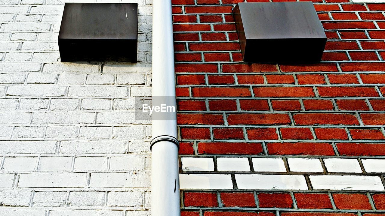 Low angle view of mailboxes on brick wall