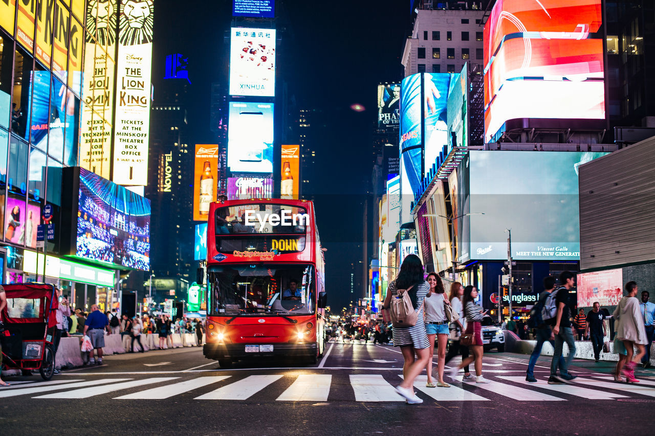 PEOPLE WALKING ON ROAD IN CITY