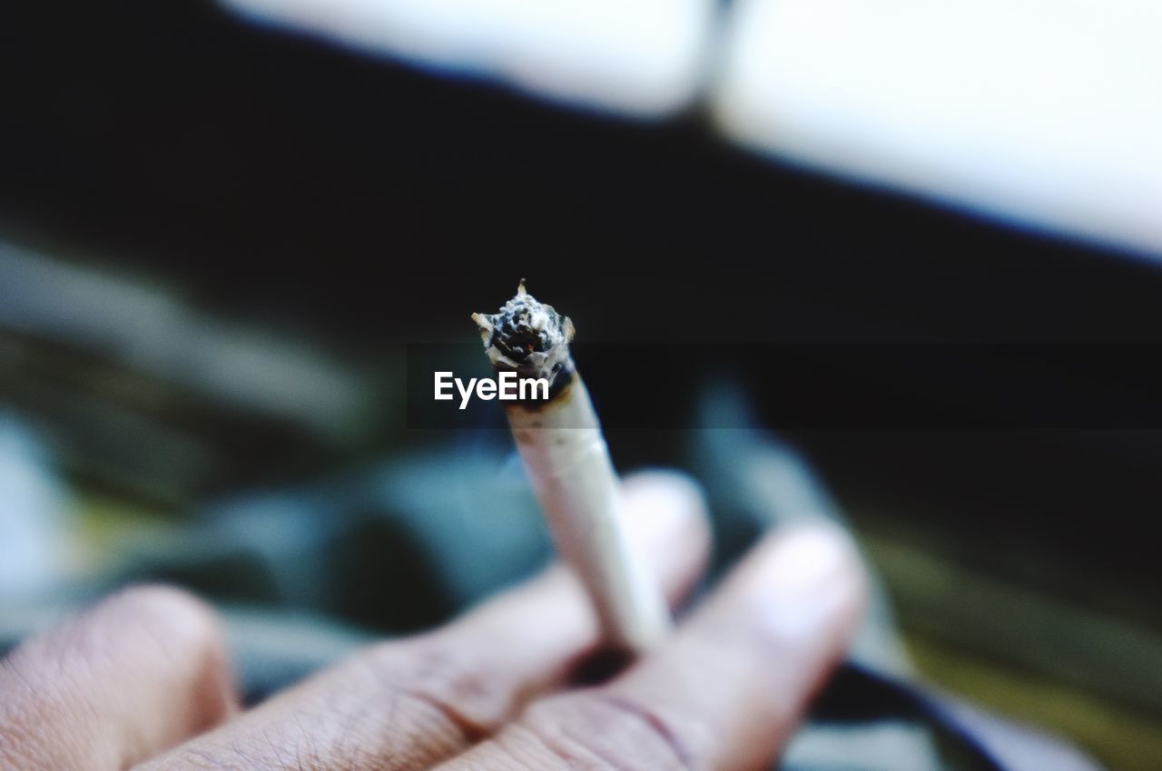 Close-up of hand holding a cigarette