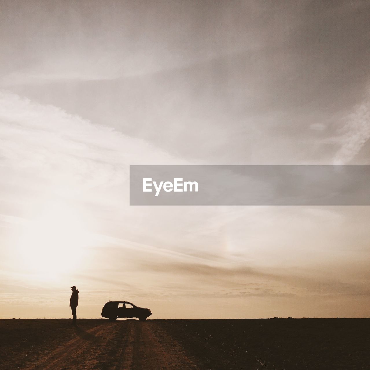 Man standing in field near car