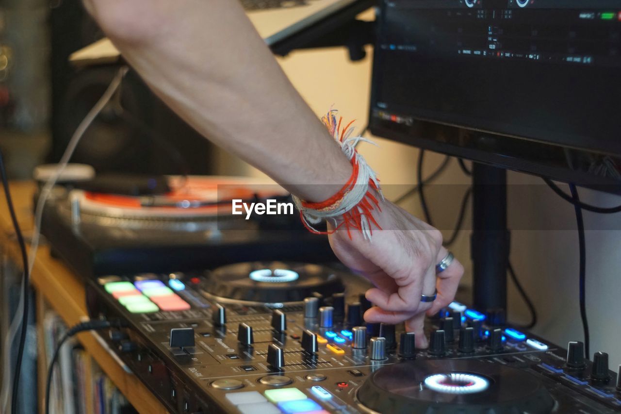 Cropped hand of man mixing music at recording studio