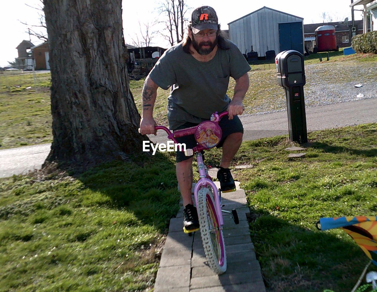 Full length of man riding bicycle on footpath