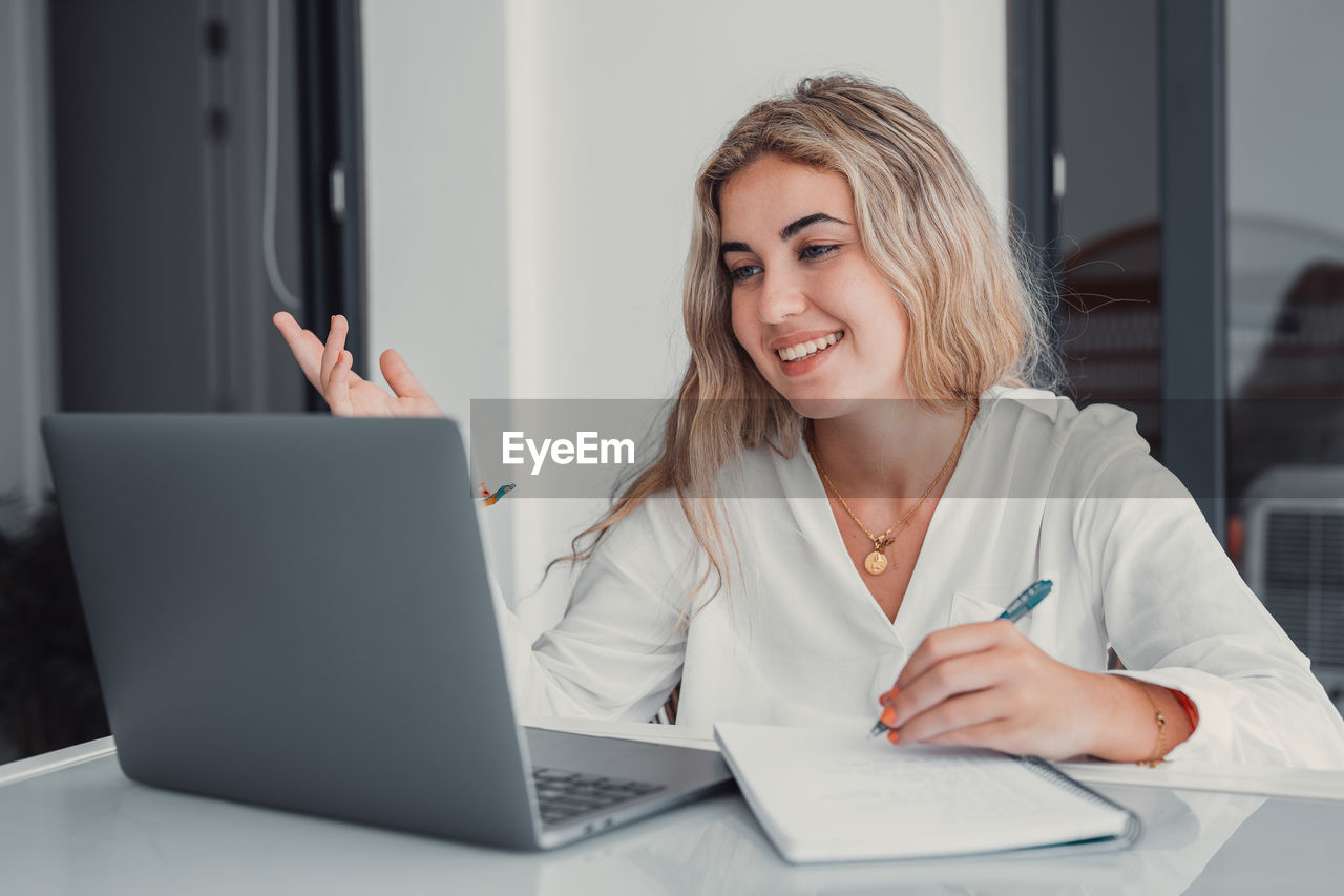 young woman using laptop while sitting at office