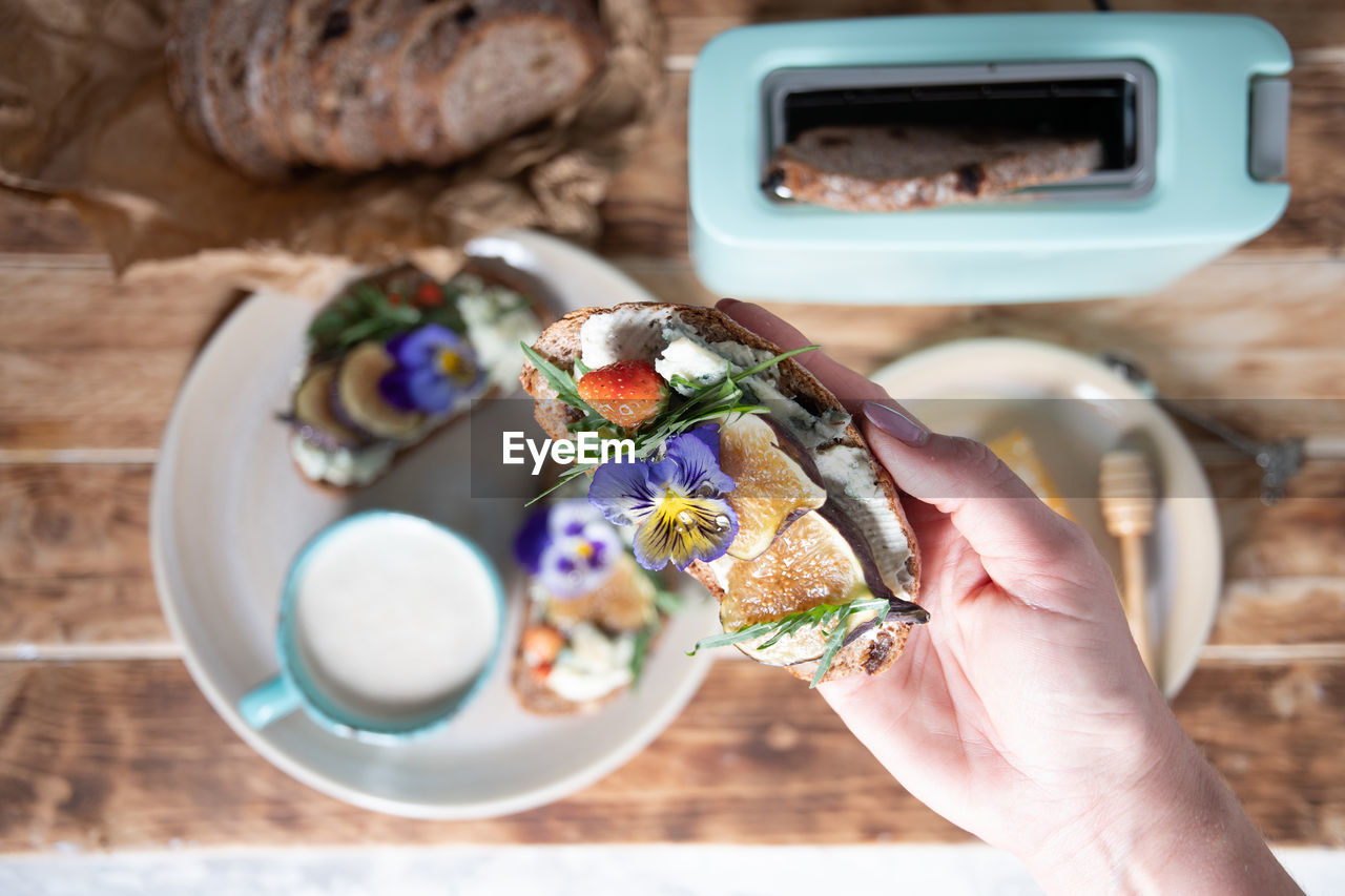 Delicious bruschetta with homemade bread, garnished with fig,soft cheese,pansies