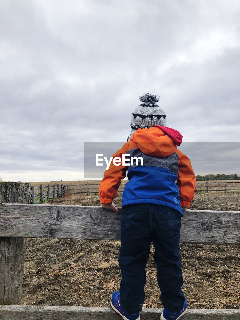 REAR VIEW OF MAN STANDING IN WINTER