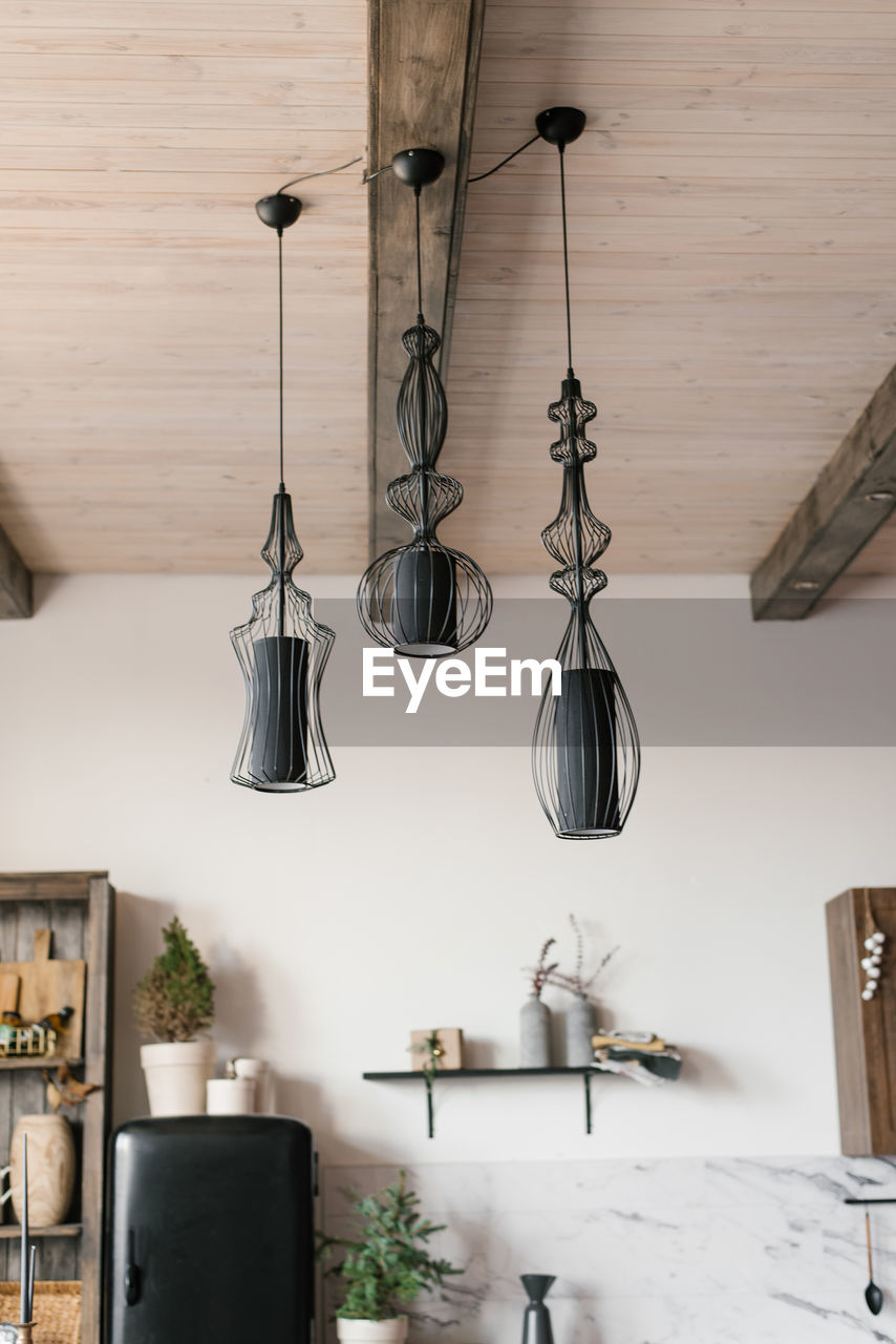 Modern black lamps on the ceiling in the interior of a wooden country house