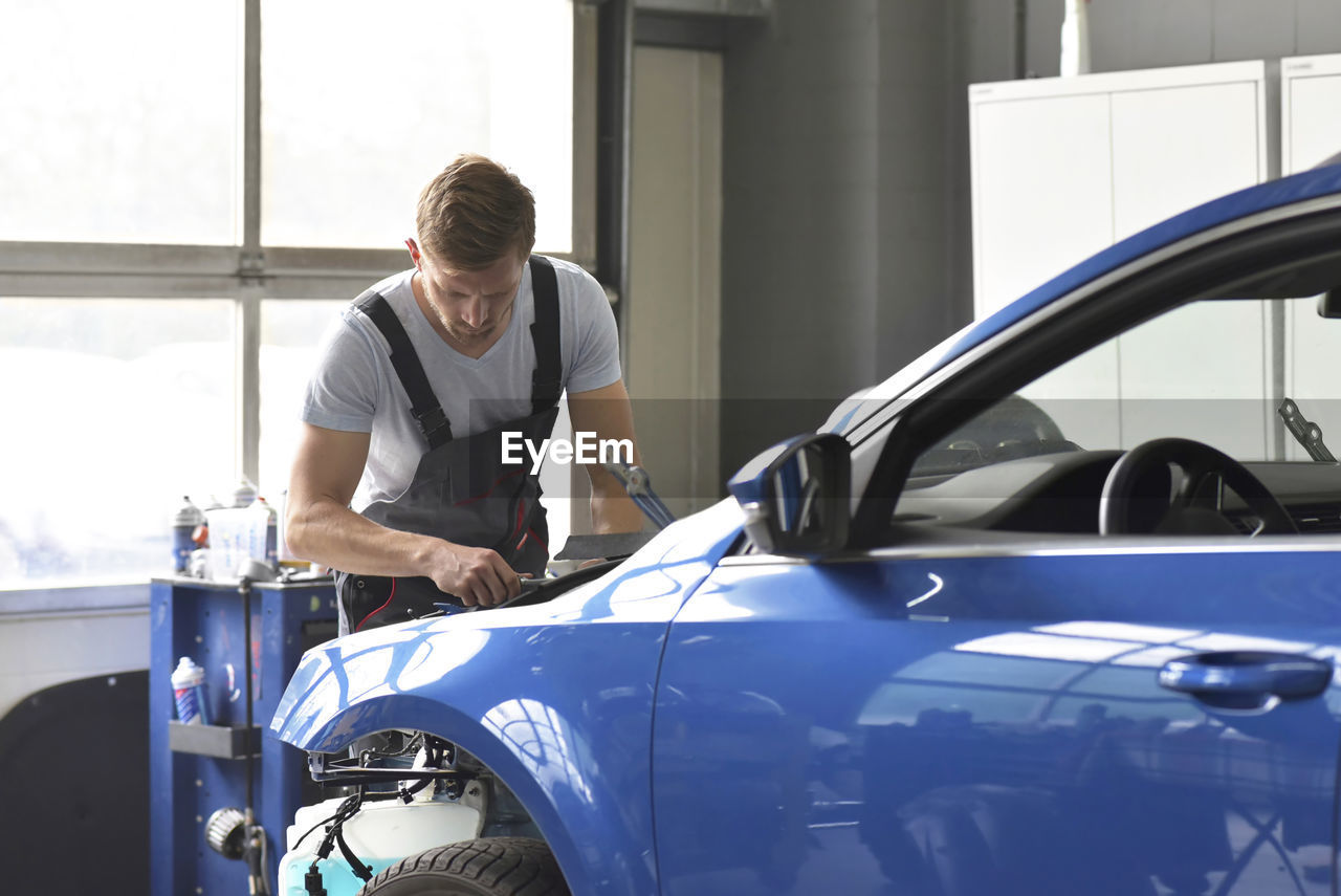 Car mechanic in a workshop working at car