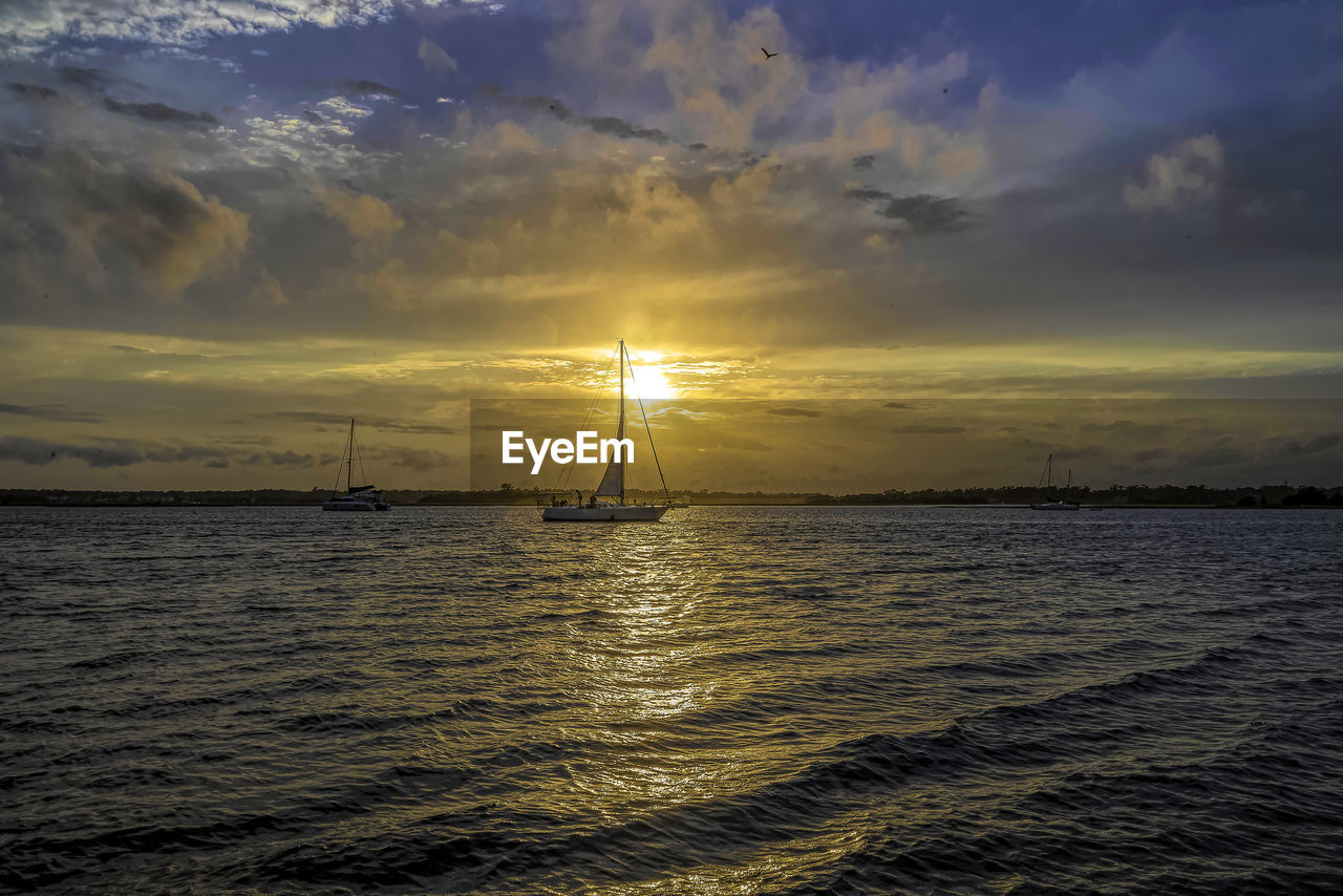 SAILBOAT ON SEA AGAINST SKY DURING SUNSET