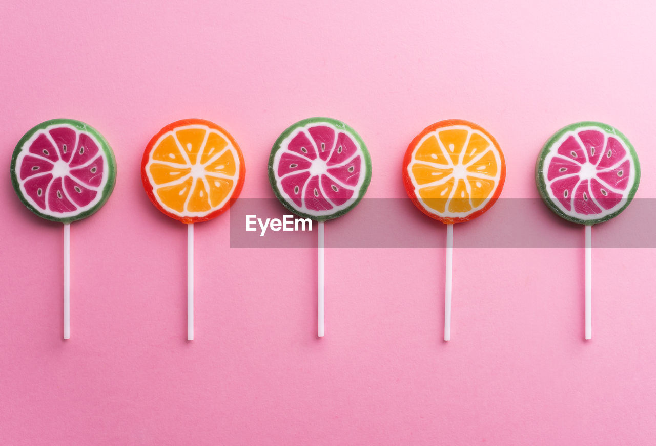 HIGH ANGLE VIEW OF MULTI COLORED CANDIES AGAINST WHITE BACKGROUND