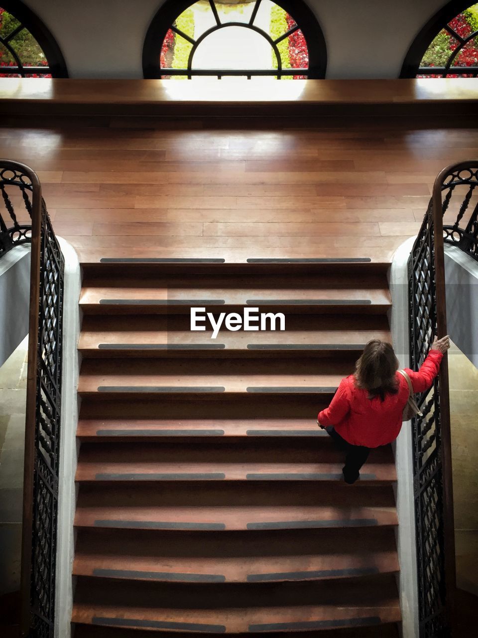 WOMAN STANDING ON STAIRS IN STAIRCASE