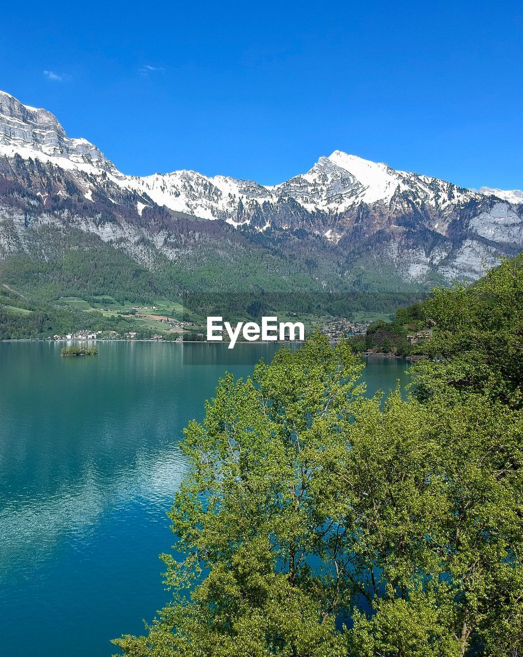 Scenic view of lake and mountains against blue sky