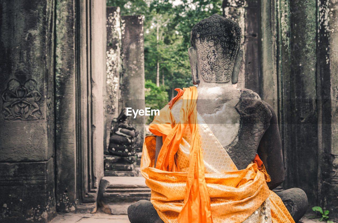 Stone statue of a seated buddha in a temple in cambodia. 