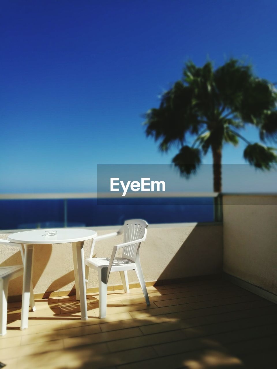 CHAIRS AND TABLES AT BEACH AGAINST CLEAR SKY