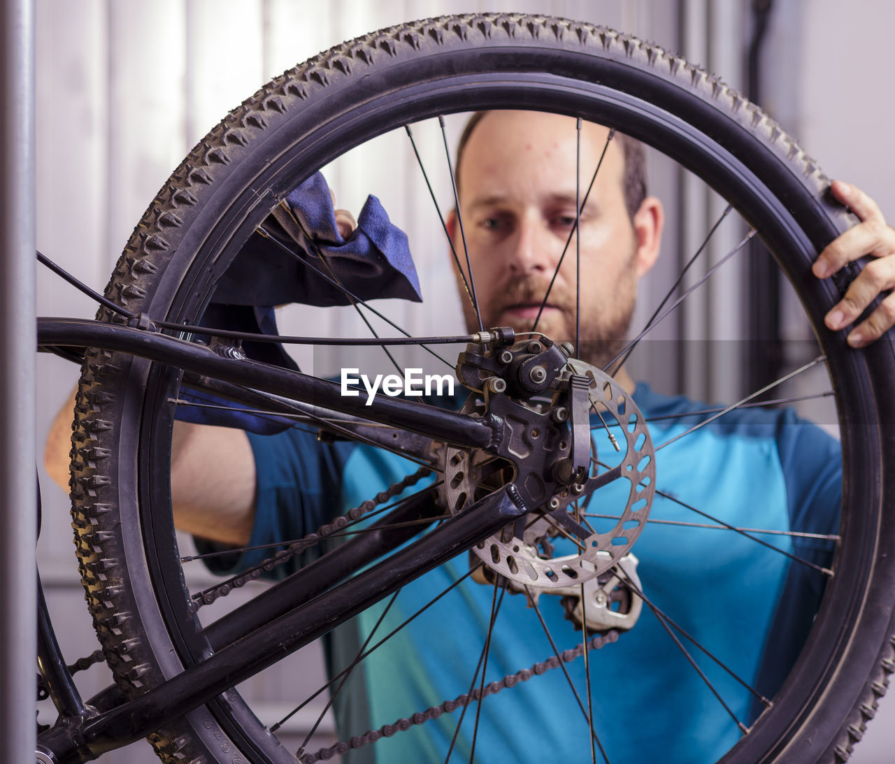 Man cleaning bicycle wheel