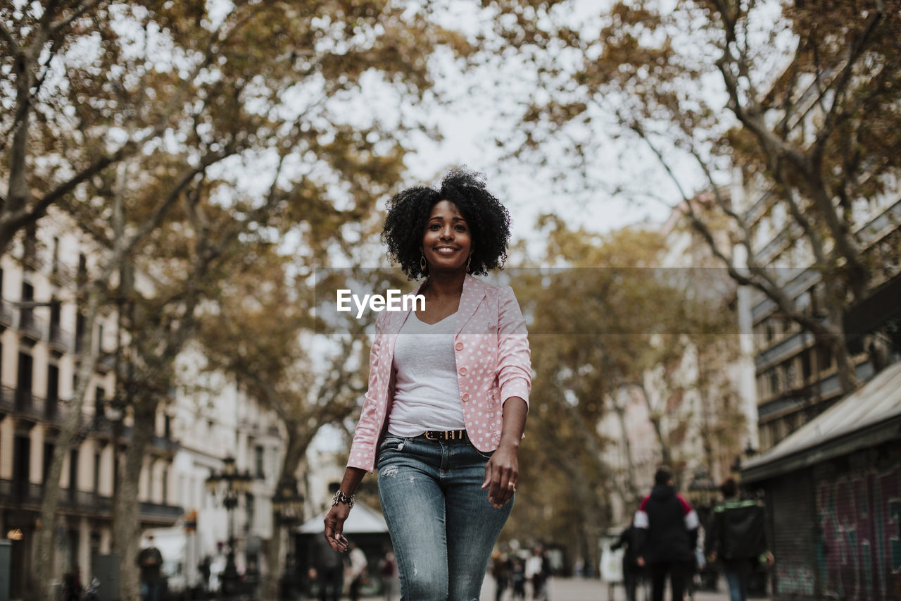 Carefree woman walking on street in city