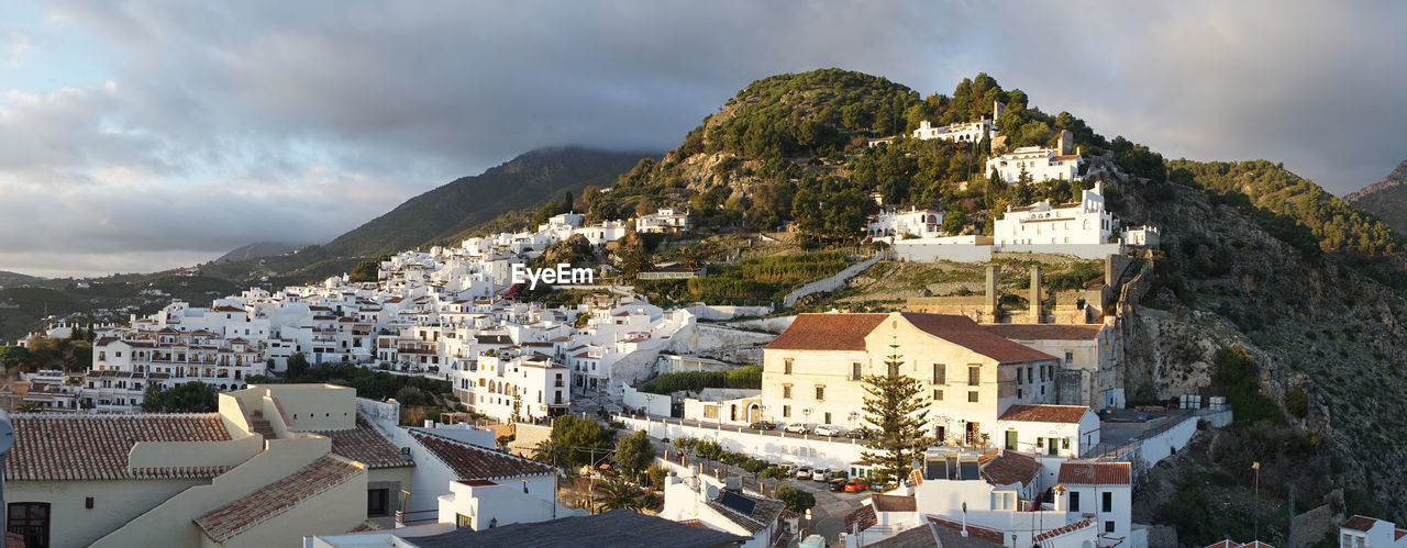 HIGH ANGLE VIEW OF BUILDINGS IN TOWN AGAINST SKY