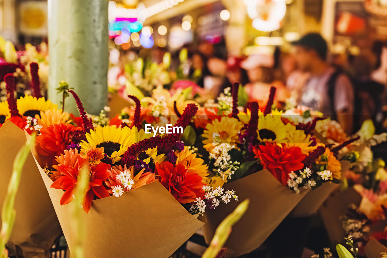 flower, flowering plant, plant, freshness, beauty in nature, yellow, nature, retail, celebration, floristry, business, market, flower arrangement, focus on foreground, multi colored, outdoors, city, arrangement, meal, business finance and industry, travel destinations, decoration, event