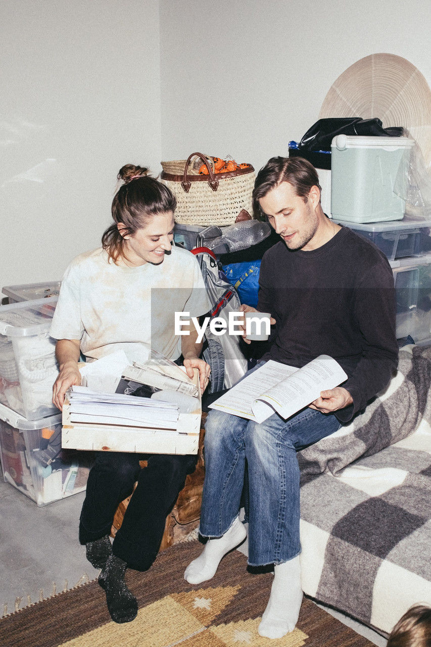 Couple reading book while sitting during relocation of house