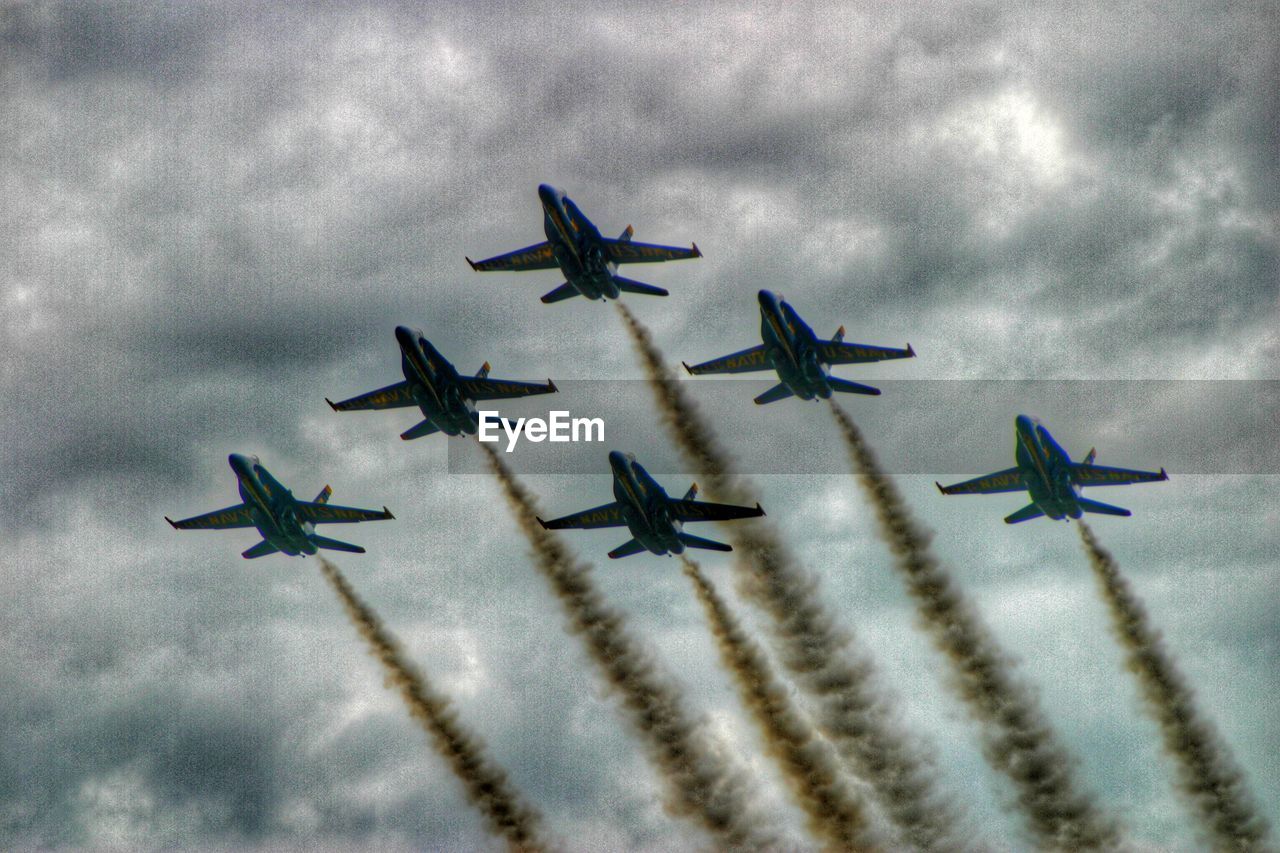 AIRPLANE FLYING OVER CLOUDY SKY