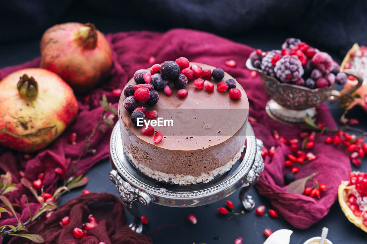 CLOSE-UP OF CAKE WITH FRUITS ON TABLE